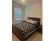 Bedroom featuring dark wooden furniture with patterned bedspread, and natural lighting at 4033 Sunrise Ridge Blvd, Groveland, FL 34736