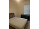 Bedroom featuring neutral tones with black dresser, wooden headboard, and natural lighting at 4033 Sunrise Ridge Blvd, Groveland, FL 34736