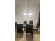Modern dining room features glass table and decorative chandelier at 4033 Sunrise Ridge Blvd, Groveland, FL 34736