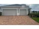 Two car garage with brick driveway leading up to this freshly painted home at 4033 Sunrise Ridge Blvd, Groveland, FL 34736