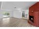 Open layout living room featuring a brick fireplace, wood-look floors, and backyard access at 45 S Edgemon Ave, Winter Springs, FL 32708