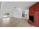 Open layout living room featuring a brick fireplace, wood-look floors, and backyard access at 45 S Edgemon Ave, Winter Springs, FL 32708
