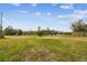 Large grassy lot with distant trees and structures at 4771 Deen Still Rd, Polk City, FL 33868