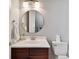 Small bathroom with a round mirror, dark vanity, and white toilet at 510 Golfpark Dr, Celebration, FL 34747