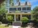 Two-story house with a wrap-around porch, brick pathway, and lush landscaping at 510 Golfpark Dr, Celebration, FL 34747