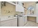 Bright laundry room with washer, dryer, storage, and sink at 510 Golfpark Dr, Celebration, FL 34747