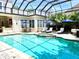 Inviting pool area with covered patio, lounge chairs, and umbrellas at 510 Golfpark Dr, Celebration, FL 34747