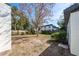 Spacious backyard featuring a tree, partial brick patio, and a surrounding wooden fence at 5438 San Luis Dr, Orlando, FL 32807