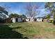Expansive backyard with a well-maintained lawn, utility shed and patio area, perfect for outdoor activities at 5438 San Luis Dr, Orlando, FL 32807