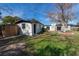 View of a backyard featuring a shed, green grass, a patio, and a large, leafy tree at 5438 San Luis Dr, Orlando, FL 32807