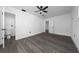 Bedroom featuring a ceiling fan, gray floors, white walls, and a view of the attached bath at 5438 San Luis Dr, Orlando, FL 32807