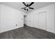 This bedroom features stylish gray flooring, a ceiling fan, and a spacious closet for ample storage at 5438 San Luis Dr, Orlando, FL 32807