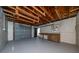 Spacious garage featuring a workbench, exposed rafters, and a large roll up garage door at 5438 San Luis Dr, Orlando, FL 32807