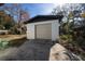 A detached garage with a beige door and white brick exterior, complemented by a concrete driveway at 5438 San Luis Dr, Orlando, FL 32807