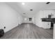 Bright open-concept living room with new gray laminate flooring, with a kitchen and entry view at 5438 San Luis Dr, Orlando, FL 32807