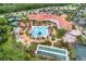Aerial view of the community clubhouse featuring pools, tennis courts, and beautifully landscaped grounds at 663 Shorehaven Dr, Poinciana, FL 34759