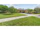 Beautiful home with manicured lawn, palm trees, and a brick driveway leading to a two-car garage at 663 Shorehaven Dr, Poinciana, FL 34759