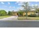 Well-maintained single-Gathering home with a lush front lawn, mature trees, and a brick driveway at 663 Shorehaven Dr, Poinciana, FL 34759