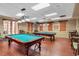 Spacious game room with two billiard tables and seating areas for entertainment at 663 Shorehaven Dr, Poinciana, FL 34759