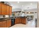 Well-lit kitchen featuring wood cabinets, a black dishwasher, and tile flooring at 663 Shorehaven Dr, Poinciana, FL 34759