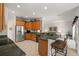 Open kitchen featuring wood cabinets, stainless steel refrigerator, and a breakfast bar with seating at 663 Shorehaven Dr, Poinciana, FL 34759