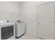 Functional laundry room with white washer and dryer, tiled floors, and storage space at 663 Shorehaven Dr, Poinciana, FL 34759