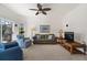 Bright living room features comfortable seating, beach-themed artwork, and neutral carpet at 663 Shorehaven Dr, Poinciana, FL 34759