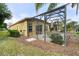 The covered patio offers an ideal area for outdoor gatherings or relaxing, surrounded by lush green landscaping at 663 Shorehaven Dr, Poinciana, FL 34759