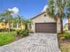 Single-story home with a brown garage door and landscaped front yard at 669 Grand Canal Dr, Kissimmee, FL 34759