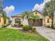 Single-story home with a brown garage door and landscaped front yard at 669 Grand Canal Dr, Kissimmee, FL 34759