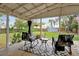 Relaxing covered back porch with comfortable seating overlooking a lush backyard at 723 New York Ave, St Cloud, FL 34769
