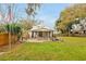 Expansive backyard with a covered patio, fire pit, outdoor kitchen, and lush lawn at 723 New York Ave, St Cloud, FL 34769