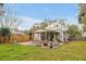 Spacious backyard with a covered patio, fire pit seating, and mature landscaping at 723 New York Ave, St Cloud, FL 34769