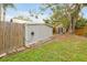 Backyard shed on grass with partial fence and large trees in the background at 723 New York Ave, St Cloud, FL 34769