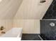 Modern bathroom showcasing black hexagon tiles in the shower and wood-look tiles above the tub at 723 New York Ave, St Cloud, FL 34769