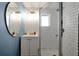 Stylish bathroom features a glass shower with white subway tile and a vanity with a large round mirror at 723 New York Ave, St Cloud, FL 34769