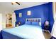 Bright bedroom featuring a blue accent wall, cozy bedding, and natural light at 723 New York Ave, St Cloud, FL 34769