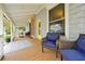 Inviting covered front porch featuring wood floors, decorative rug, and comfortable seating area at 723 New York Ave, St Cloud, FL 34769
