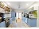 Bright kitchen with blue cabinets, black countertops, stainless steel appliances, and tile floors at 723 New York Ave, St Cloud, FL 34769
