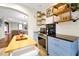 Open kitchen with wood floors, blue cabinets, stainless steel appliances, and decorative shelving at 723 New York Ave, St Cloud, FL 34769