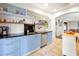Modern kitchen with blue cabinets, stainless steel appliances, and access to the living area at 723 New York Ave, St Cloud, FL 34769