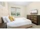 Bright bedroom with a queen-size bed, dresser, and large window at 771 Drop Shot Dr, Davenport, FL 33896