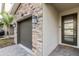 Modern front entrance with stonework, two-car garage, and a welcoming mat at 771 Drop Shot Dr, Davenport, FL 33896