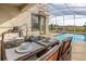 Outdoor patio dining area with seating for four, adjacent to the pool and spa at 771 Drop Shot Dr, Davenport, FL 33896