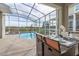 Screened patio with pool, spa, and outdoor dining area at 771 Drop Shot Dr, Davenport, FL 33896