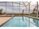 Inviting screened pool and spa with a tranquil view at 771 Drop Shot Dr, Davenport, FL 33896
