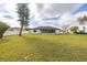 Vast grassy backyard showcasing the home's exterior, perfect for recreation and outdoor activities at 83 Alameda Dr, Kissimmee, FL 34743