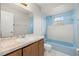 Bathroom featuring single sink vanity and blue tiled tub/shower at 83 Alameda Dr, Kissimmee, FL 34743