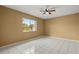 Bright bedroom featuring tile floors, ceiling fan, and a large window providing natural light at 83 Alameda Dr, Kissimmee, FL 34743