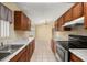 Long kitchen layout with tile floors, dark cabinets, and stainless steel appliances at 83 Alameda Dr, Kissimmee, FL 34743